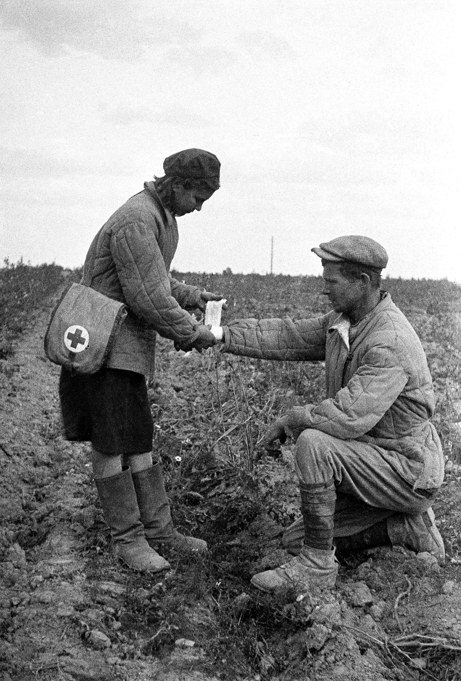 Санитарка сандружины Сухаревской средней школы оказывает медицинскую помощь механизатору колхоза «Новая жизнь». Автор – С.И. Васин. Московская обл., пос. Сухарево. 1942 г. Главархив Москвы